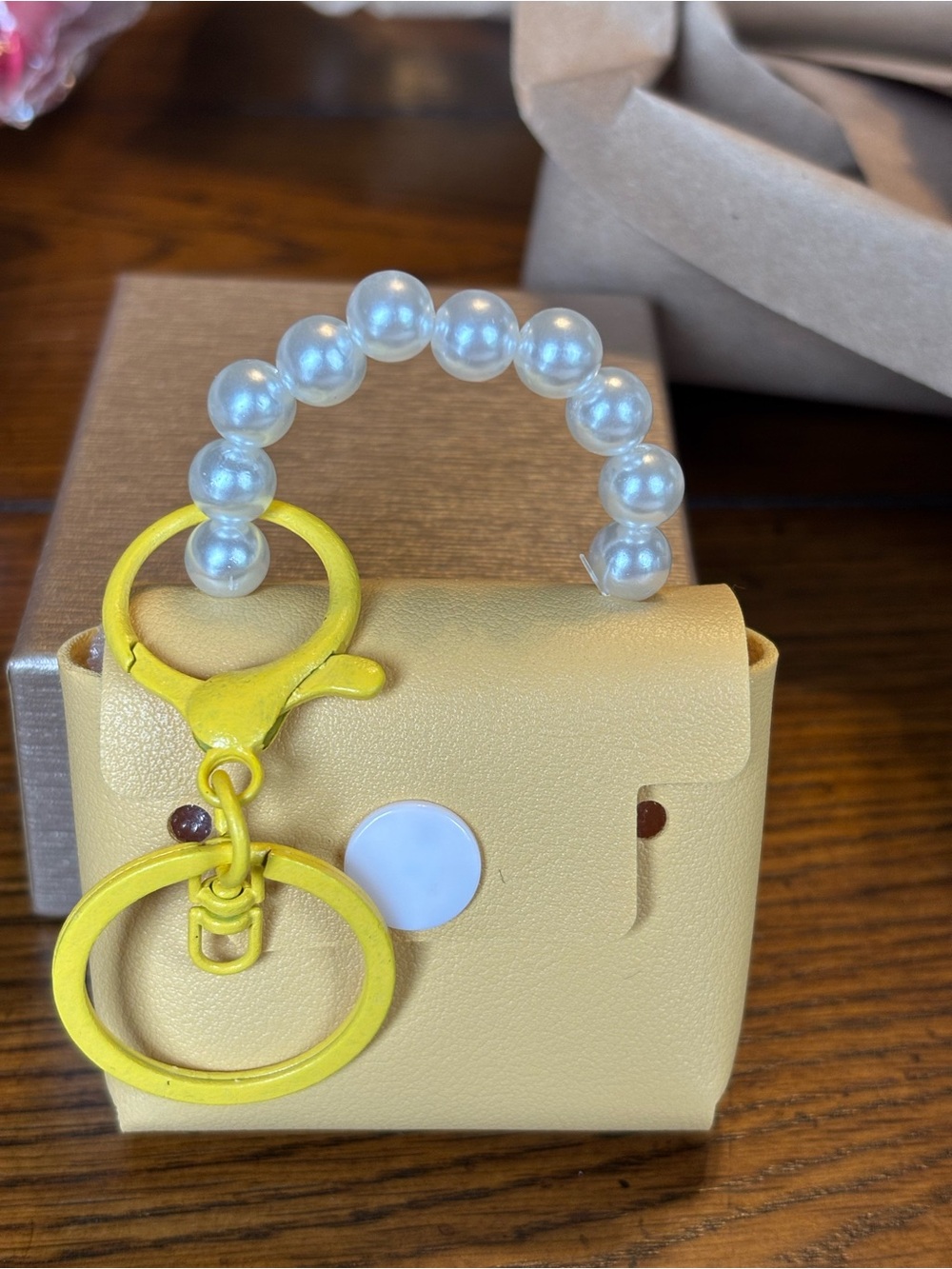 Mini purse key chain with faux pearls for handle. Has a snap that works  yellow